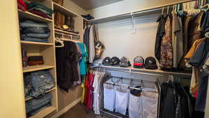 Spacious closet featuring dark carpet