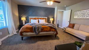 Bedroom featuring carpet flooring, ceiling fan, and an accent wall