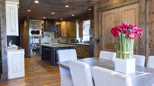 Kitchen featuring wooden ceiling, a center island, light stone counters, recessed lighting, and dark wood finished floors