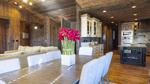 Dining space featuring wood ceiling, dark wood-style floors, recessed lighting, vaulted ceiling, and wood walls