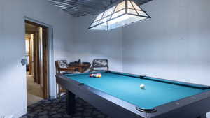 Rec room with dark colored carpet and billiards table