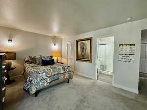 Bedroom featuring carpet floors, a closet, a textured ceiling, and ensuite bathroom