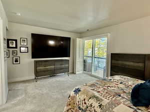 Carpeted bedroom with access to exterior and baseboards