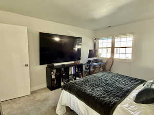 Bedroom featuring light colored carpet and baseboards