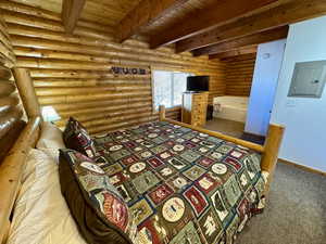 Bedroom featuring carpet, log walls, electric panel, a wood ceiling with exposed beams, and a textured wall