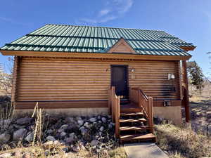 Log cabin with log exterior and a metal roof