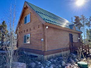 View of side of property with log exterior and a metal roof
