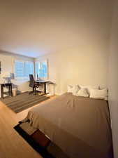 Bedroom featuring wood finished floors and an office area