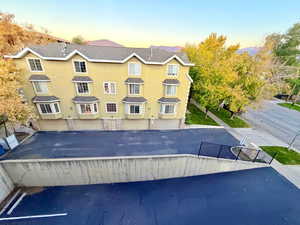 View of front facade with stucco siding and roof with shingles