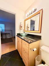 Bathroom with vanity and dark tile patterned floors