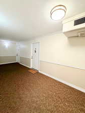 Carpeted empty room with crown molding