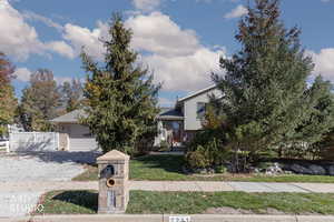 View of front of home featuring brick siding, concrete driveway, a garage, and a front yard