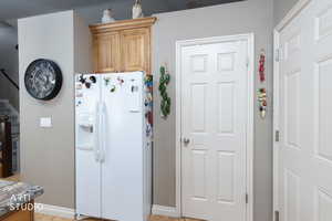 Kitchen with white fridge with ice dispenser and light wood-type flooring