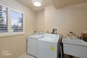 Washroom with washing machine and clothes dryer and baseboards
