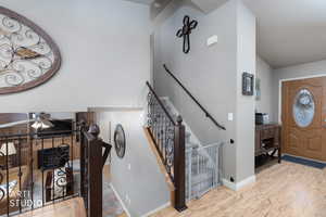Entrance foyer with light wood finished floors, a fireplace, and ceiling fan