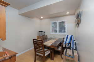 Dining room with light wood-type flooring and recessed lighting