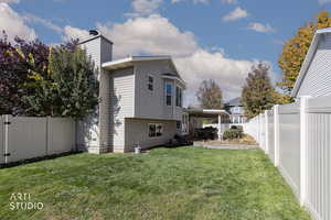 Back of house with a fenced backyard, a patio, and a chimney