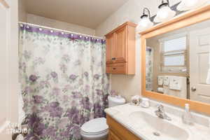 Bathroom with a shower with shower curtain, vanity, and a textured wall