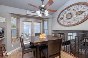 Dining room with light wood-style flooring, plenty of natural light, and a ceiling fan