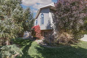 View of home's exterior with a yard and brick siding