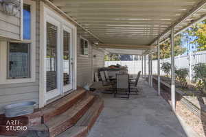 Fenced backyard with outdoor dining area, entry steps, and a patio
