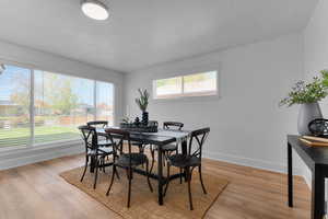 Dining space with light wood-style floors and a textured ceiling