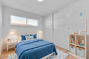 Bedroom with light wood-style floors and a closet