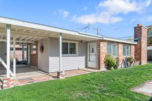Ranch-style house with a front lawn, brick siding, and a chimney