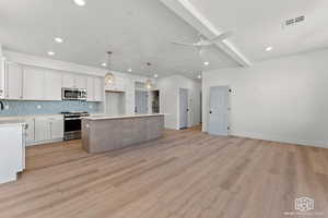 Kitchen featuring beamed ceiling, backsplash, appliances with stainless steel finishes, hanging light fixtures, and white cabinets