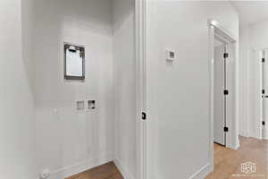 Laundry room with hookup for a washing machine and light wood-style flooring