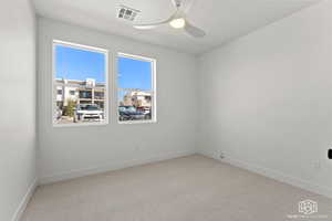 Carpeted empty room featuring baseboards and ceiling fan