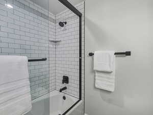 Bathroom with shower / bath combination with glass door