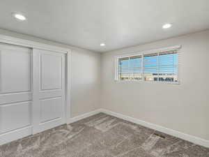 Unfurnished bedroom featuring carpet floors, a closet, and recessed lighting