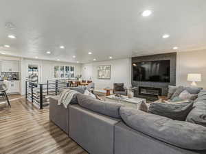 Living room with wood finished floors, recessed lighting, a textured ceiling, and a large fireplace
