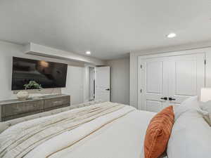 Bedroom featuring a closet, recessed lighting, and a textured ceiling