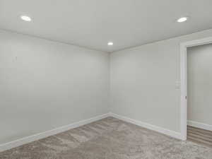Empty room with carpet and recessed lighting