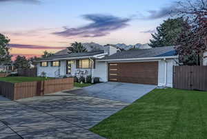 Ranch-style home with driveway, a gate, roof with shingles, brick siding, and a chimney