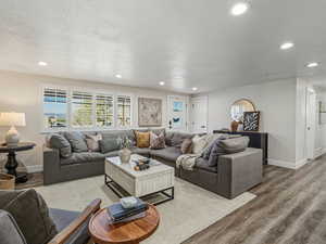 Living area with recessed lighting, wood finished floors, and a textured ceiling