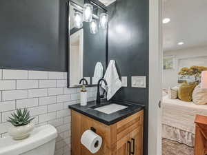 Ensuite bathroom with vanity, tile walls, and recessed lighting