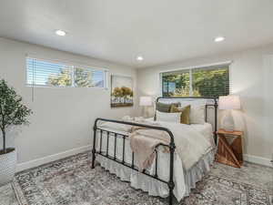 Carpeted bedroom with multiple windows, recessed lighting, and a textured ceiling