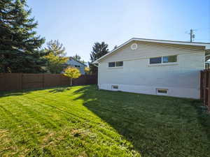 View of property exterior with a fenced backyard and brick siding