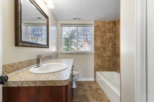 Full bath with vanity and a textured ceiling