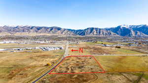 Aerial view of sparsely populated area with property parcel outlined and mountains