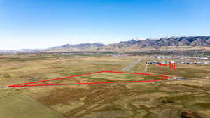 Aerial view of property and surrounding area featuring property boundaries highlighted, rural landscape, and mountains