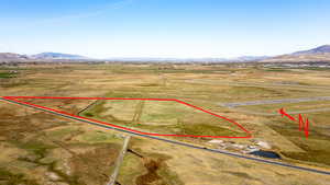 Aerial view of sparsely populated area featuring property parcel outlined and mountains