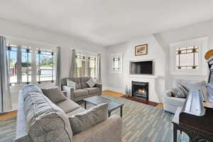 Living room with a large fireplace and wood finished floors