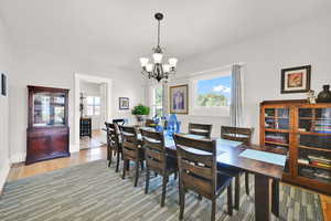 Dining space featuring light wood-style floors, plenty of natural light, and a chandelier
