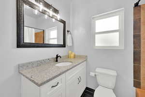 Full bathroom with vanity, a shower with shower curtain, and dark tile patterned floors