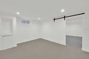 Below grade area featuring a barn door and recessed lighting