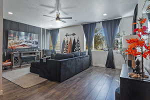 Living area featuring a textured ceiling, hardwood / wood-style flooring, ceiling fan, recessed lighting, and a glass covered fireplace